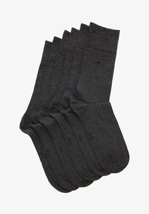 Calzini di cotone grigio scuro disposti in un mucchio, con un bordo a coste e una texture liscia, dotati di un delicato logo vicino alla punta.
