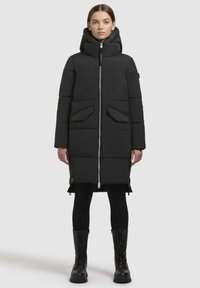 Schwarze Daunenjacke mit hohem Kragen und Reißverschluss, ausgestattet mit zwei Fronttaschen und einem knielangen Design. Strukturierte, matte Oberfläche.