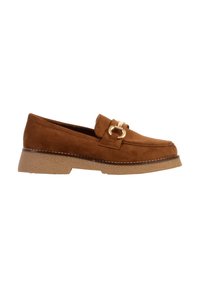 Mocassin en daim marron avec une semelle en caoutchouc beige et un détail boucle en métal doré sur le dessus.