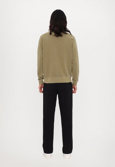 Oliven grøn sweatshirt med ribstrikkede manchetter og kant, parret med sorte bukser. Sweatshirten har en afslappet pasform og et enkelt design.