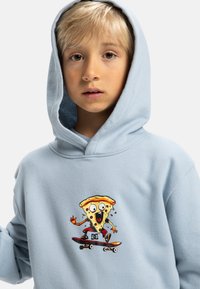 Felpa leggera blu chiaro con un personaggio di pizza in stile cartone animato che scia, con dettagli vivaci e un design giocoso sul davanti. Texture del tessuto morbida.