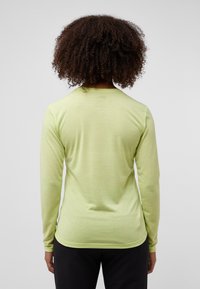 Langärmliges Hemd aus leicht grünem Stoff, mit einer glatten Textur und figurnahem Design, runder Kragen und leicht abgerundetem Saum.