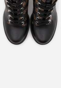 Černé šněrovací boty s hladkým koženým špičkou a vzorovaným textilním svrškem v hnědých a béžových odstínech. Stříbrné kovové očka a černé tkaničky.