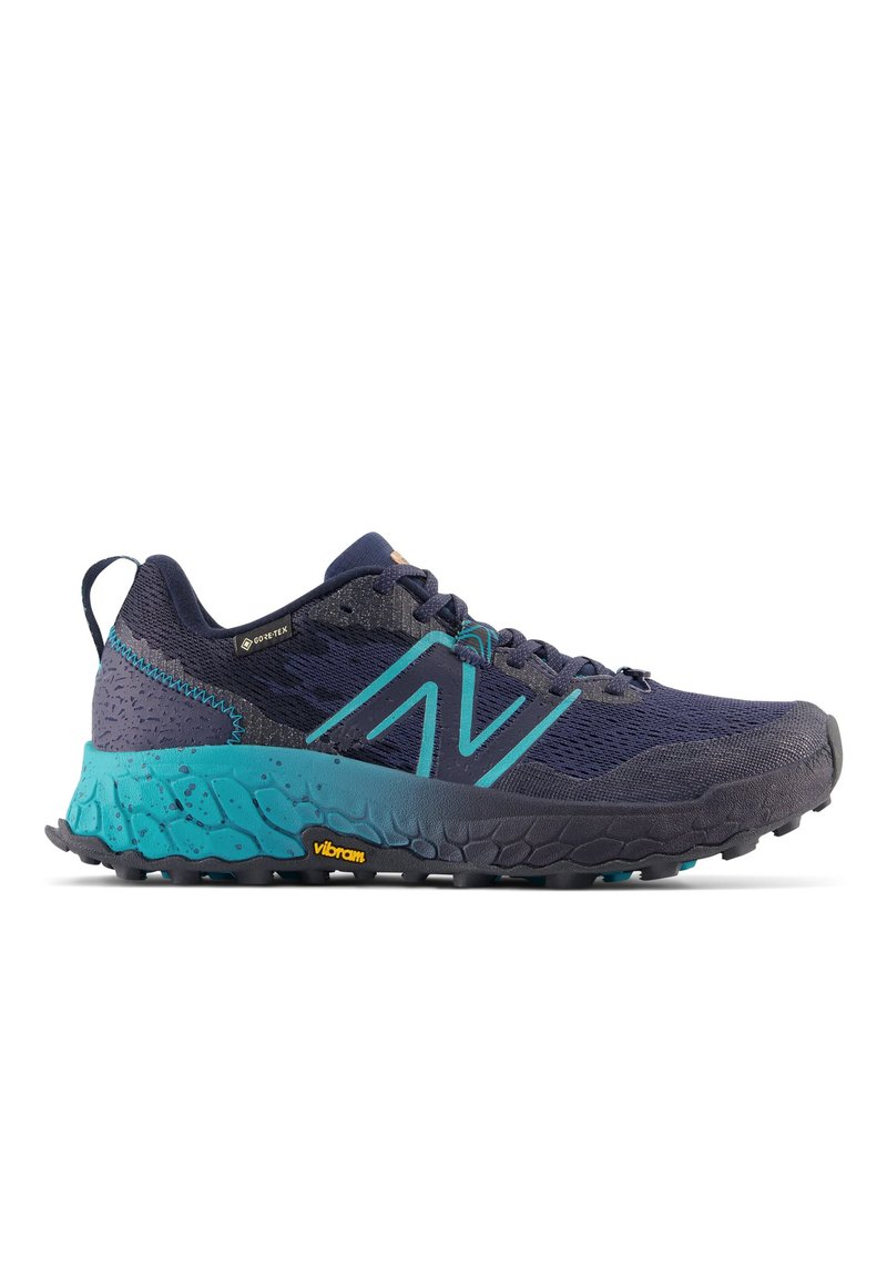 Zapatilla de correr en azul marino y verde azulado, con una parte superior texturizada, suela acolchada y suela Vibram para agarre. Cuenta con un diseño de cordones y talón reforzado.