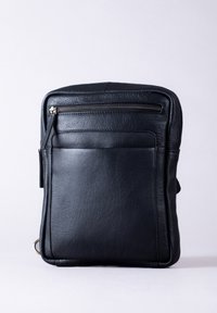 Black leather bag with a textured finish. Features a top zip closure, front zip pocket, and a structured rectangular shape.