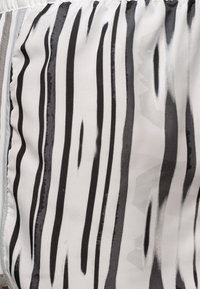 Black and white striped fabric with a smooth texture. The stripes vary in thickness, creating a dynamic pattern across the material.
