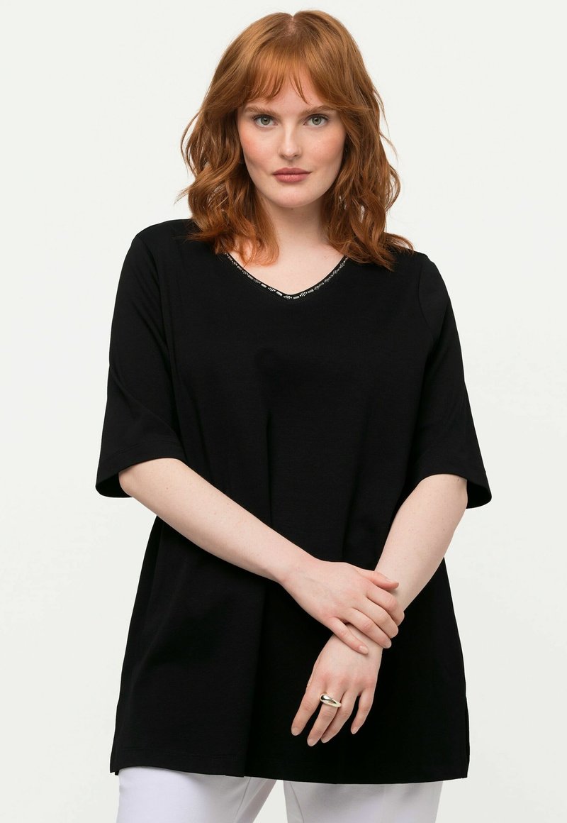 Top corto a maniche corte nero con scollatura a V e collo decorato, realizzato in materiale morbido; vestibilità rilassata e spacchi laterali per il massimo comfort.