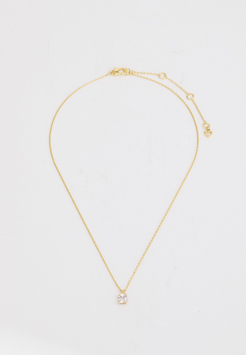 Zelta ķēdes kaklarota ar delikātu saites dizainu un skaidru kvadrātveida piekari vidū. Iekļauts neliels sirsniņas formas akcentu tuvumā aizdarei.