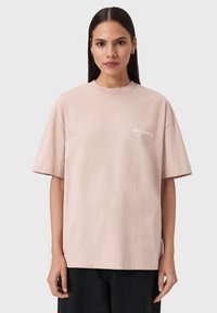 Lichtroze oversized katoenen t-shirt met korte mouwen. Heeft een klein "ALLSAINTS" logo in het wit op de linkerborst.