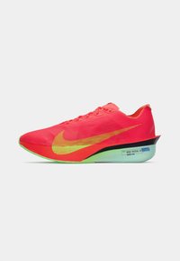 Chaussure de course Nike en rose vif avec un swoosh jaune dégradé. Caractérisée par une tige en mesh légère, une semelle verte et un design aérodynamique élégant.