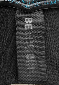 Tissu noir texturé avec un motif bleu émaillé proéminent. Comprend une étiquette latérale portant le mot "BETHON" dans une police audacieuse.