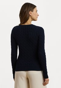 Maglione navy blue a treccia con orlo e polsini a coste, caratterizzato da un design testurizzato e aderente. Il retro presenta un classico scollo rotondo.