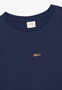 T-shirt bleu marine à col rond avec petit logo "Blkvis" orange brodé sur la poitrine et une étiquette de taille "L" sur le col intérieur.