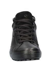 Czarne skórzane sneakersy typu high-top z okrągłym noskiem, płaską gumową podeszwą i teksturowanym językiem. Posiadają tradycyjne sznurowanie oraz subtelne logo.