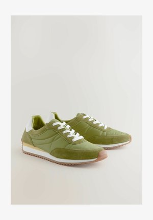 Zelene tenisice od kombinacije glatkog i antilop materijala, bijelih vezica, gumeni potplat i niskoprofilni dizajn.