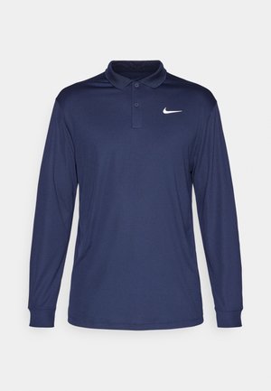 Camisa polo de manga longa em azul marinho, feita de tecido leve, apresentando um colarinho elevado, lista de botões e um logotipo da Nike branco no lado esquerdo do peito.