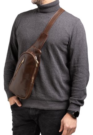 Borsa a tracolla in pelle marrone con due tasche con zip, tracolla regolabile, superficie liscia e forma arrotondata, indossata attraverso il torso.