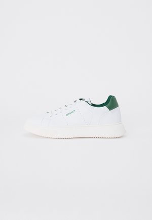 Hvite joggesko med grønne detaljer, laget av glatt skinn. Har et lavt design, rund tå og en teksturert gummisåle.