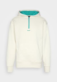 Sweat à capuche blanc avec intérieur turquoise, fermeture éclair au quart sur le devant, poche avant, et logo "huf". Comprend des poignets et un ourlet côtelés. Matière douce en mélange de coton.