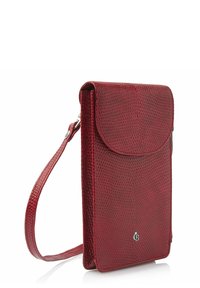Housse de téléphone en cuir rouge avec une surface texturée, une fermeture à rabat et une sangle ajustable pour un transport facile. Présente un détail de logo sur le devant.