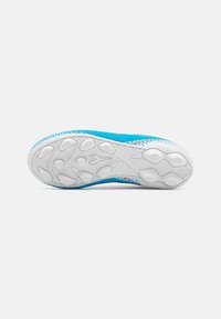 Parte inferiore di una scarpa sportiva blu con suola bianca testurizzata e motivo di grip; presenta una superficie superiore liscia e accenti colorati lungo i bordi.