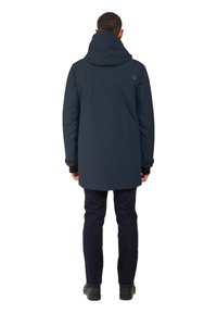 Mörkblå, vattentät parkas med huva, långa ärmar och justerbara ärmslut. Har en slät yta och en minimal logotyp på baksidan.