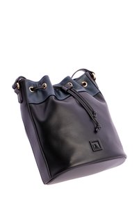 Bolso de cuero negro tipo bucket con cierre de cordón, ojales dorados, correa para el hombro ajustable y logotipo cuadrado en relieve en la parte frontal.