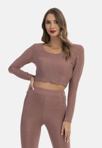 Rózsaarany fémes anyagú crop top és leggings szett. Hosszú ujjú, kerek nyakkivágású és rugalmas fazonú. Sima felület, finom fényű.