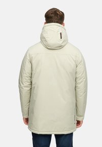 Lys beige parkas med avtagbar hette, glatt tekstur og sidelommer. Har et logomerke på baksiden og en lengre kant.