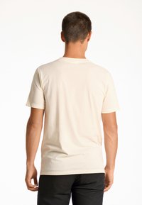 Kermakuvioinen lyhythihainen t-paita, jossa on klassinen pyöreä kaula-aukko. Valmistettu pehmeästä puuvillasta. Sileä rakenne, minimaalinen muotoilu ilman näkyviä logoja tai kuvioita.