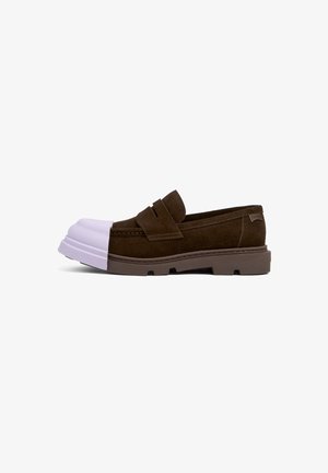 Brauner Wildleder-Pantoffel mit einer weißen Gummi-Zehenkappe, strukturierten Akzenten und einer dicken braunen Gummisohle mit Profildetails.