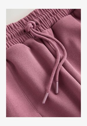 Pantaloni scurți roz cu textură nervurată, talie elastică și șnur de strângere asortat. Prezintă capete mici din plastic pe șnur.