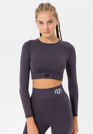 Purple long-sleeve crop top with ribbed texture and black logo. Paired with high-waisted ribbed leggings featuring grey accent details.