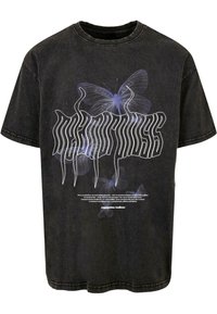 Schwarzes oversized T-Shirt mit weißen und blauen Schmetterlingsgrafiken, stilisiertem Textdesign und rundem Halsausschnitt mit sichtbaren Nähten.