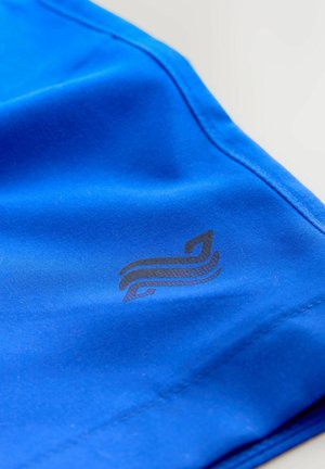 Plavi sportski materijal glatke teksture, s crnim logotipom s zakrivljenim linijama na lijevoj strani i ojačanim šavovima.