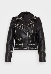 Veste de moto en cuir noir avec des clous en argent sur les épaules, les revers et l'ourlet. Comprend une fermeture éclair, une taille ceinturée et une poche poitrine.