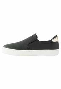 Chaussure noire à enfiler avec tige en cuir texturé, semelle en caoutchouc blanche et un accent métallique au talon. Présente un design lisse et minimaliste.