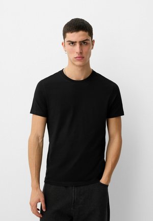 Schwarzes Baumwoll-T-Shirt mit kurzen Ärmeln, rundem Halsausschnitt und taillierter Form. Keine sichtbaren Muster oder Grafiken. Einfaches Design, vielseitiger Stil.