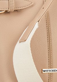 Borsa a tracolla sintetica beige con una fascia elastica bianca e accessori in oro. Presenta un'etichetta con il marchio "WITTCHEN" impresso.