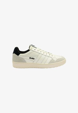Zapatilla de cuero blanca con acentos de ante gris, talón negro, tres franjas horizontales blancas en el lateral y un logo en el lado lateral.