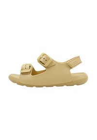 Lyse beige sandaler lavet af tekstureret gummi med to justerbare spænder og en polstret rem for komfort. Åben tå og flad såldesign.