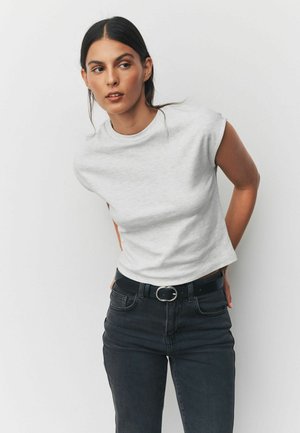Gray, short-sleeve, fitted t-shirt with a round neckline, paired with black jeans and a black belt featuring a circular buckle.
