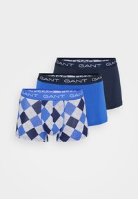 Trei perechi de boxeri pentru bărbați: una cu un model argyle albastru și navy, una albastră uniformă și una navy uniformă, toate având un tiv cu logo-ul GANT.