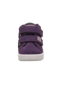 Sválenka v purpurové semišové kůži s kulatou špičkou, bílou gumovou podrážkou a dvěma nastavitelnými popruhy pro bezpečné uchycení.