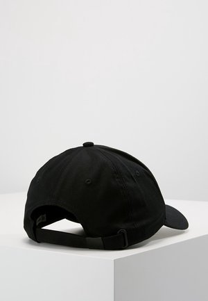 Schwarze Baseballkappe mit verstellbarem Riemen hinten, auf einem weißen Podest vor einem einfarbigen hellgrauen Hintergrund platziert.