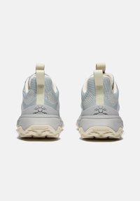 Helle graue Sportschuhe mit einem atmungsaktiven Obermaterial aus Mesh, strukturiertem Gummisohle und Zuglasche. Auffälliges Logo an der Ferse und multidirektionales Profil.