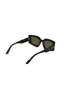 Occhiali da sole angolari con montature nere e motivo tartarugato, lenti verdi e dettagli metallici sulle aste.