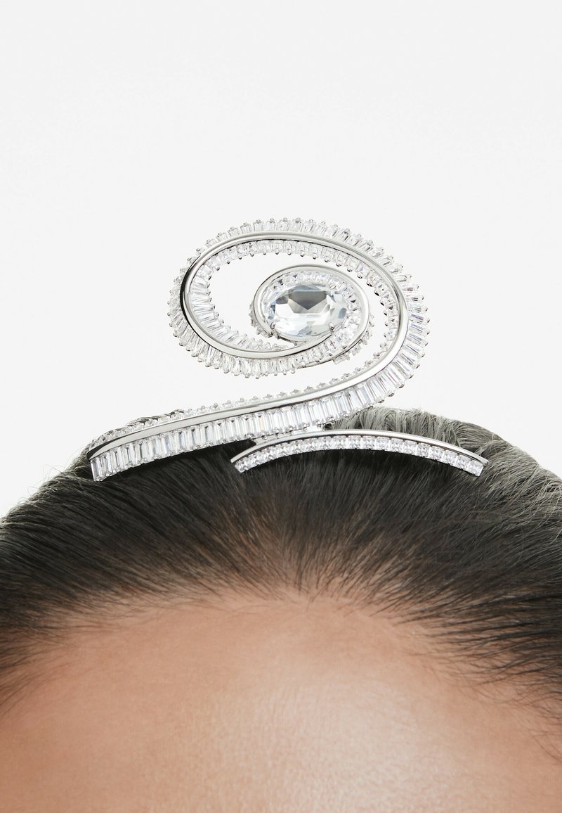 Un accessoire capillaire décoratif présentant un design en spirale avec un grand gemme clair au centre et de plus petites pierres le long des bords.