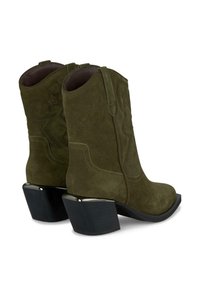 Bottes de cowboy en daim vert olive avec un design en relief en forme d'étoile, bout arrondi et talon noir épais. Texture lisse avec des détails cousus.