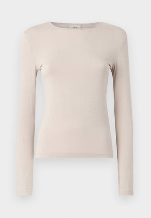 Long-sleeve light beige top made of soft fabric. Features a crew neckline and a fitted design, with minimal stitching detail.